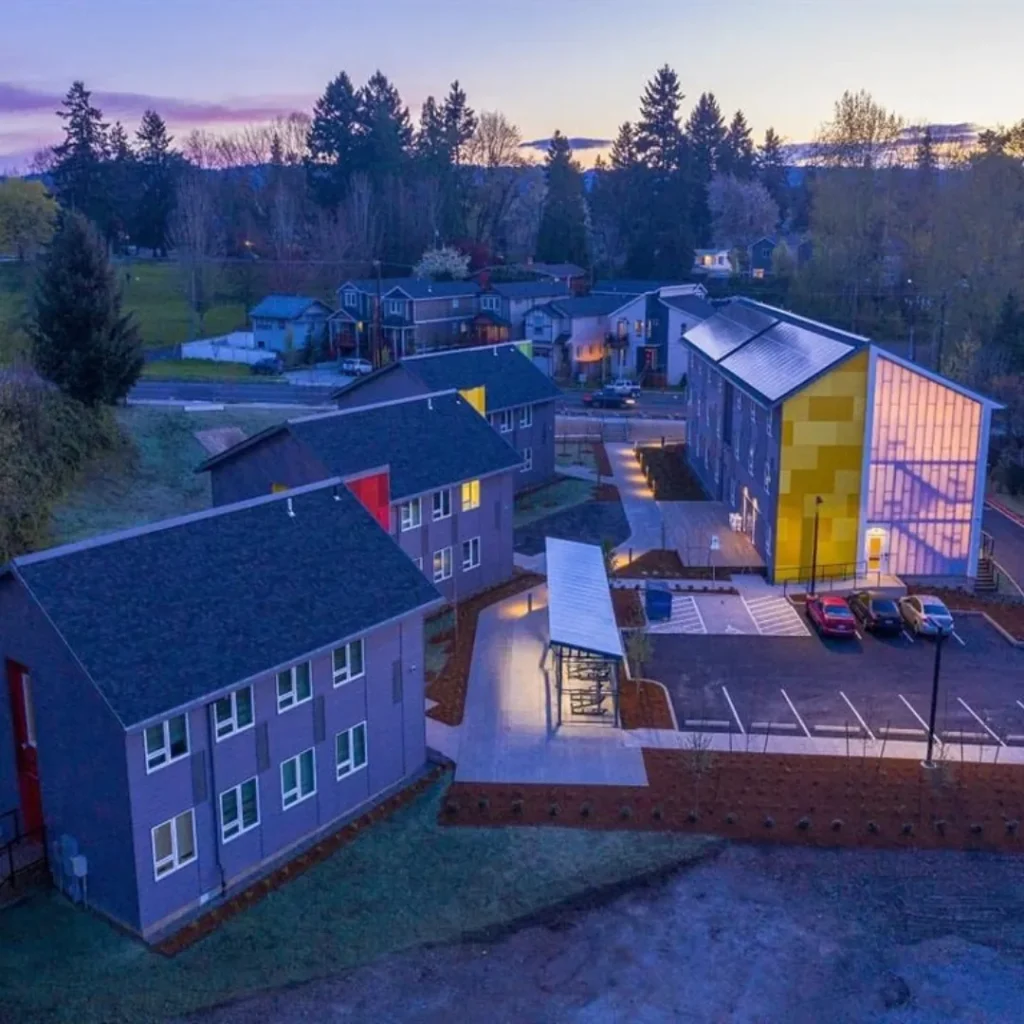 Argyle Gardens courtyard, covered bike parking, and three-story apartment building at dusk